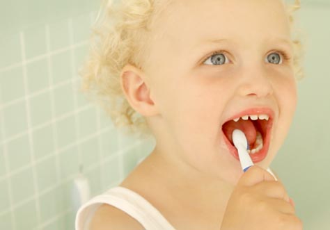 [Translate to latvian:] kid cleaning teeth